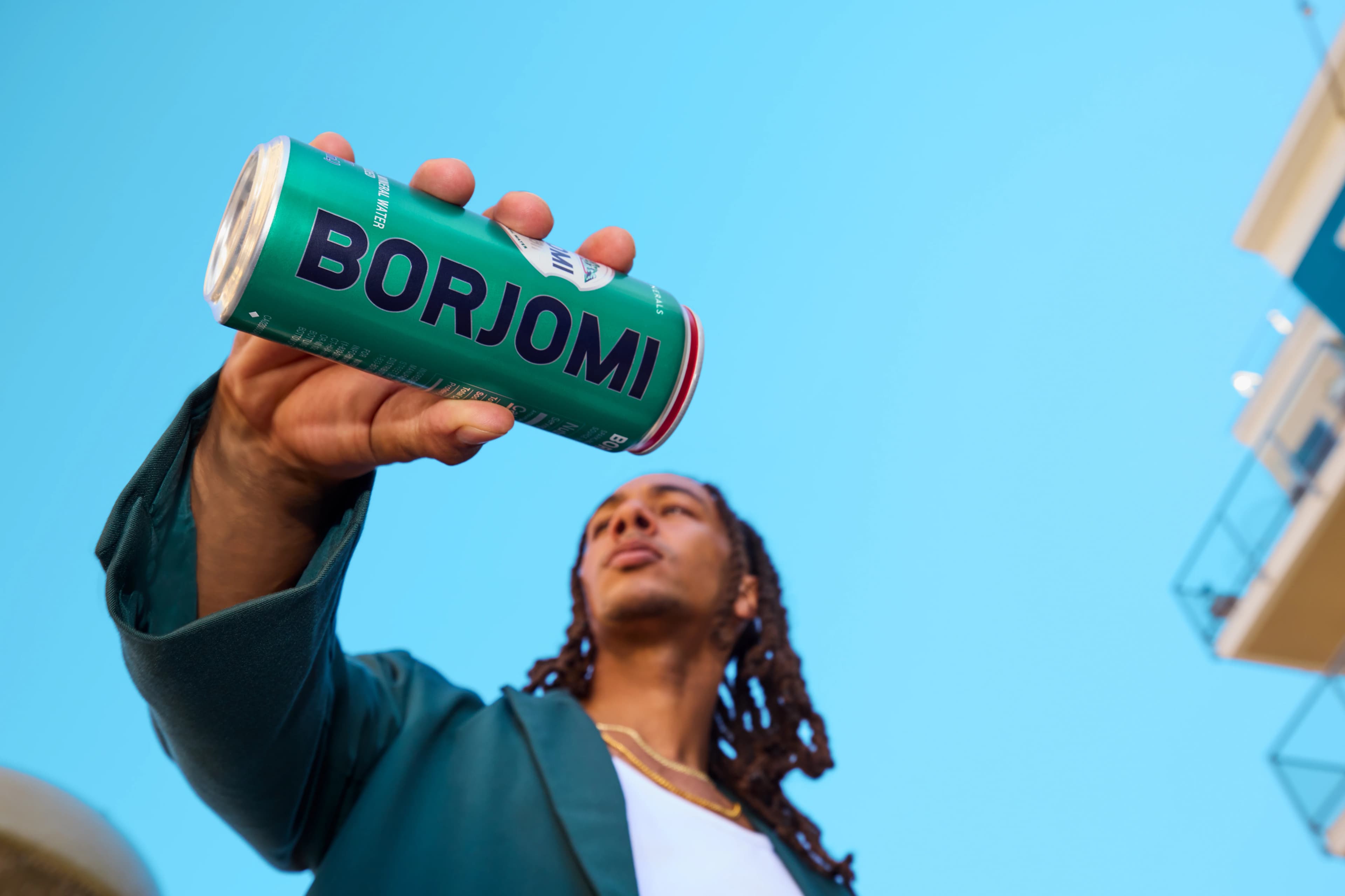Person holding a Borjomi can up to the sky